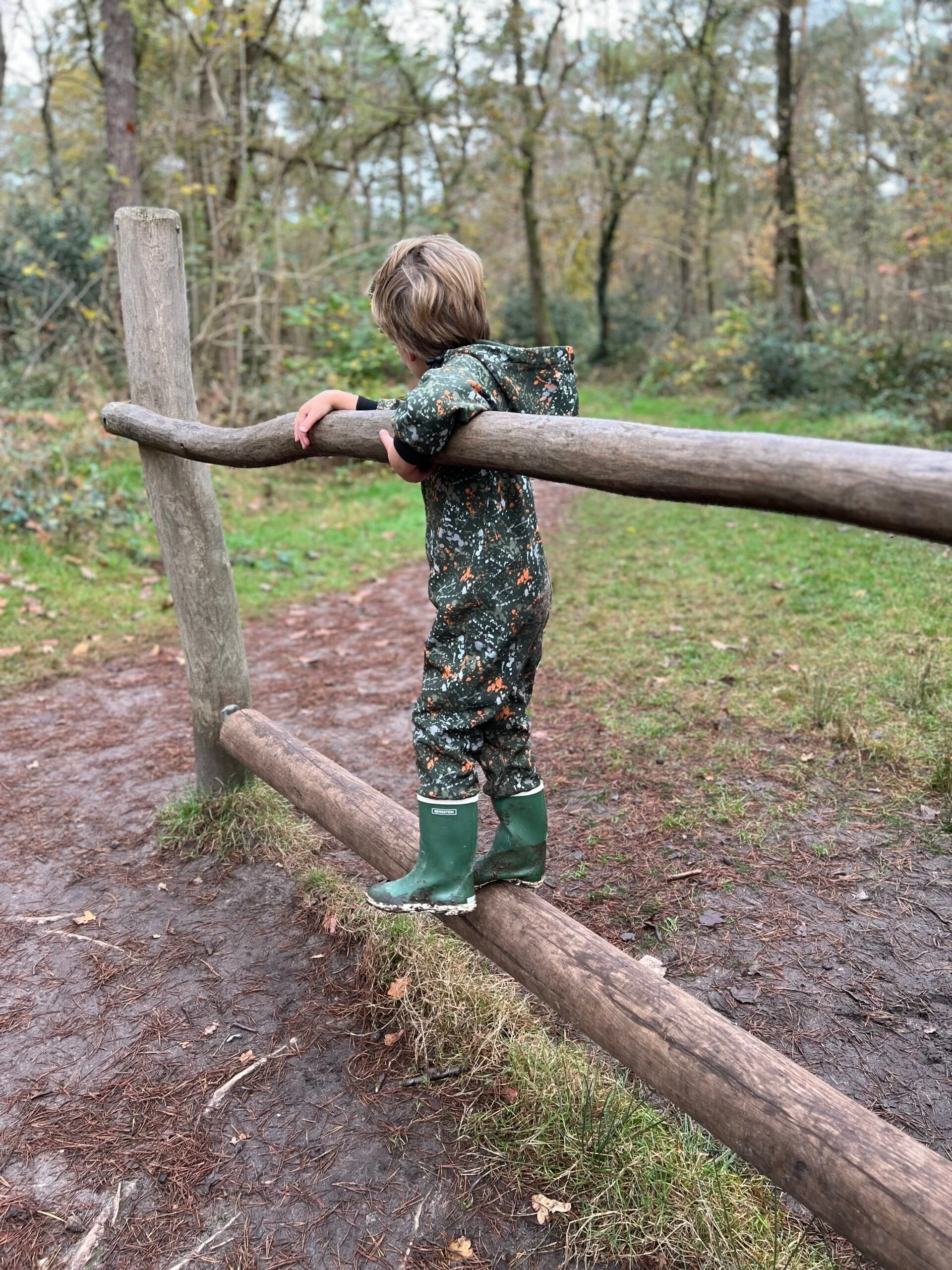 Kind speelt op een houten speeltoestel op het Struin- en Duinpad in Norg, Drenthe
