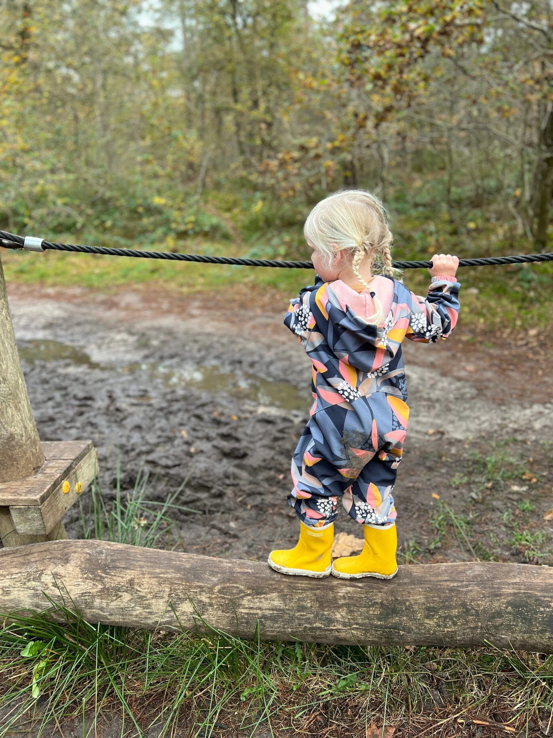 Kind klimt op een houten hindernis op het Struin- en Duinpad in Norg, Drenthe