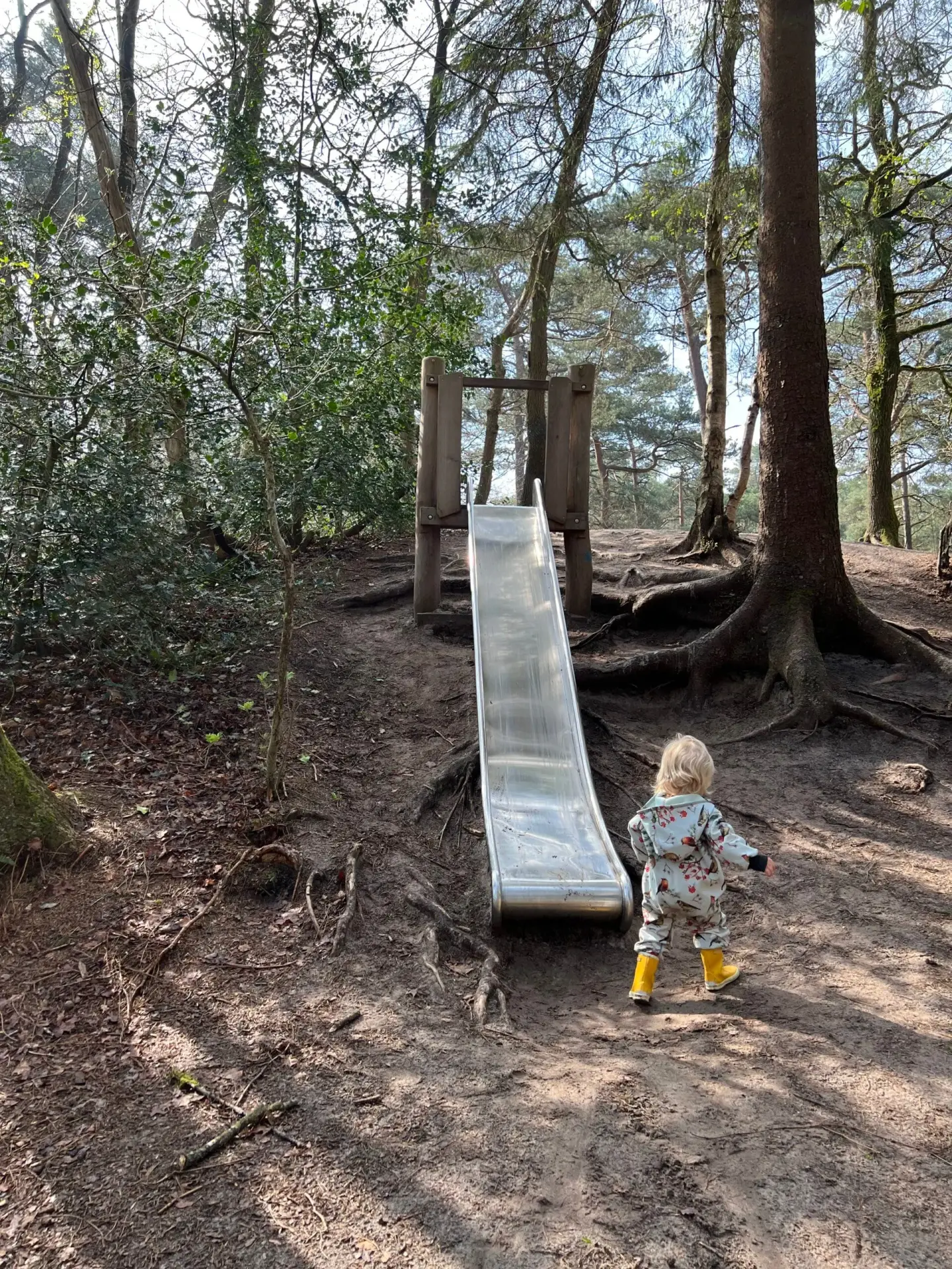 Kind speelt bij de glijbaan op het Struin- en Duinpad in Norg, Drenthe