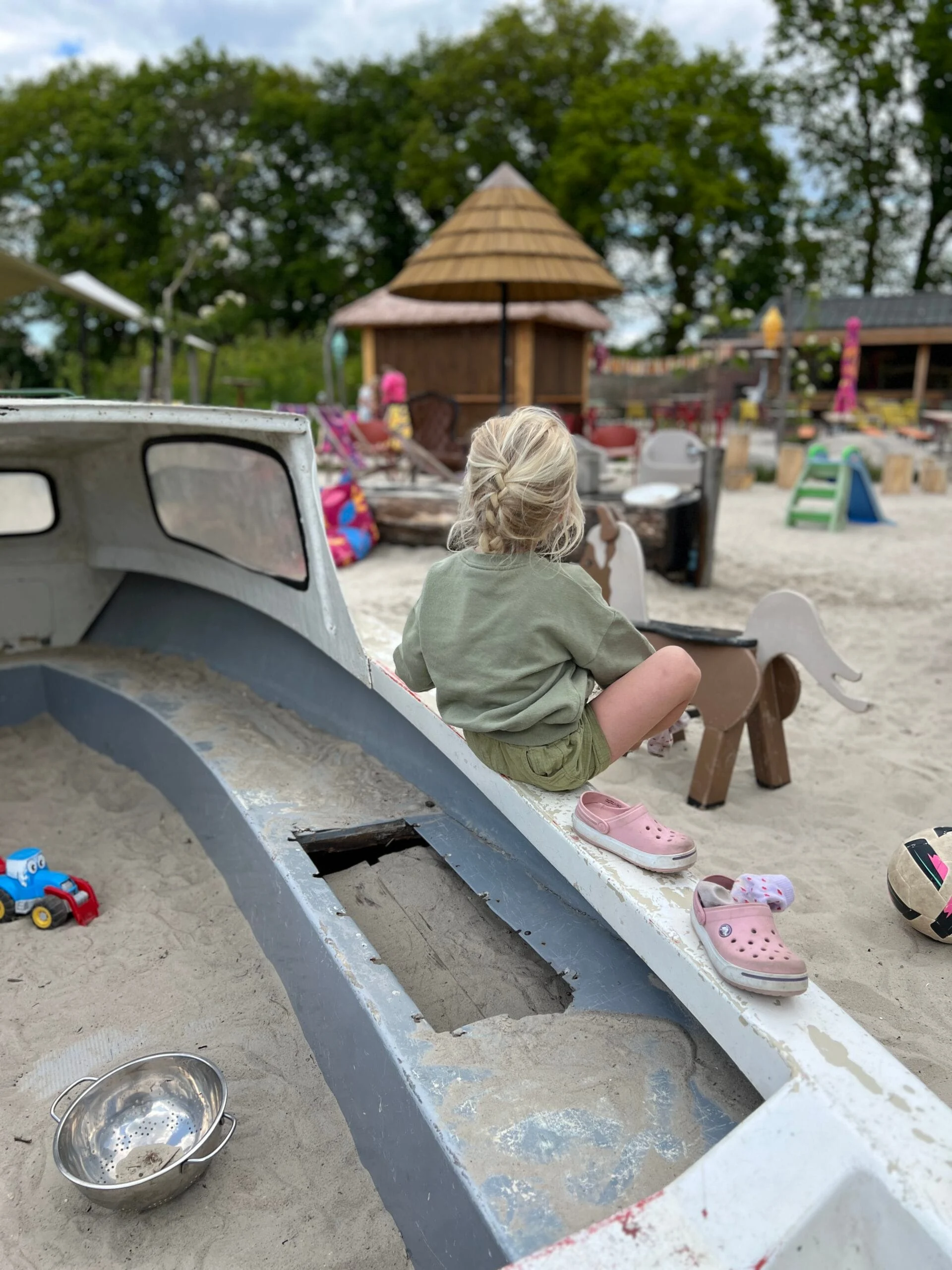 Kind speelt met zand in de speeltuin van Camping De Kleine Wereld