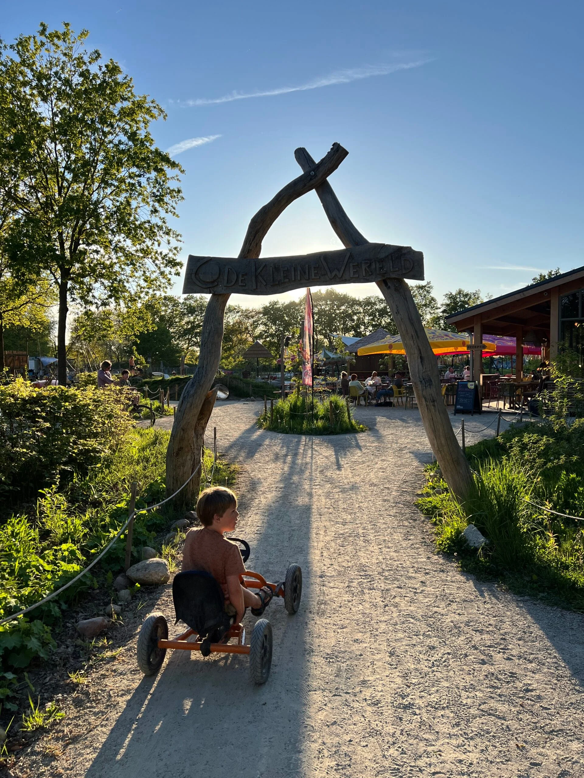 Kind rijdt op skelter bij de ingang van Camping De Kleine Wereld