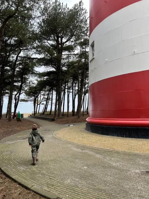 Kind loopt bij de vuurtoren van Ameland