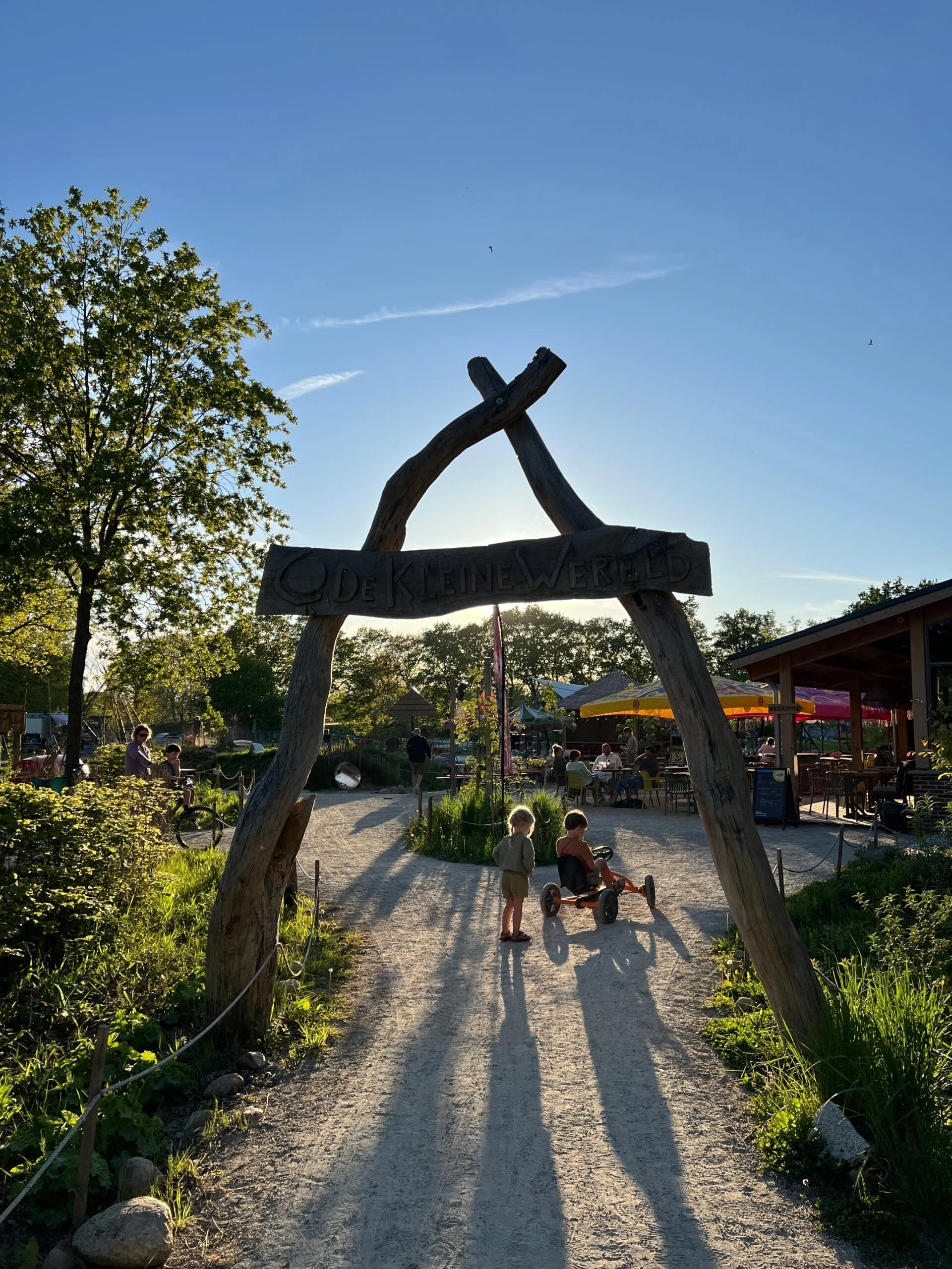Kinderen onder de poort van Camping De Kleine Wereld in Groningen