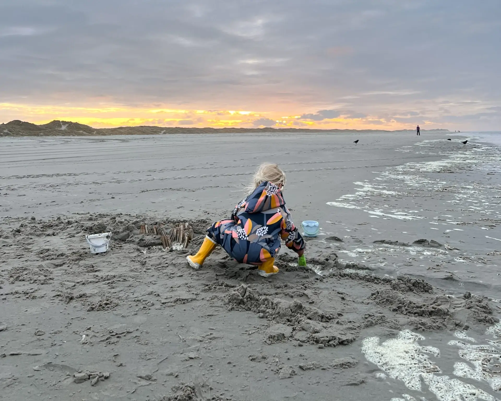 Kind speelt op het strand van Terschelling bij zonsondergang