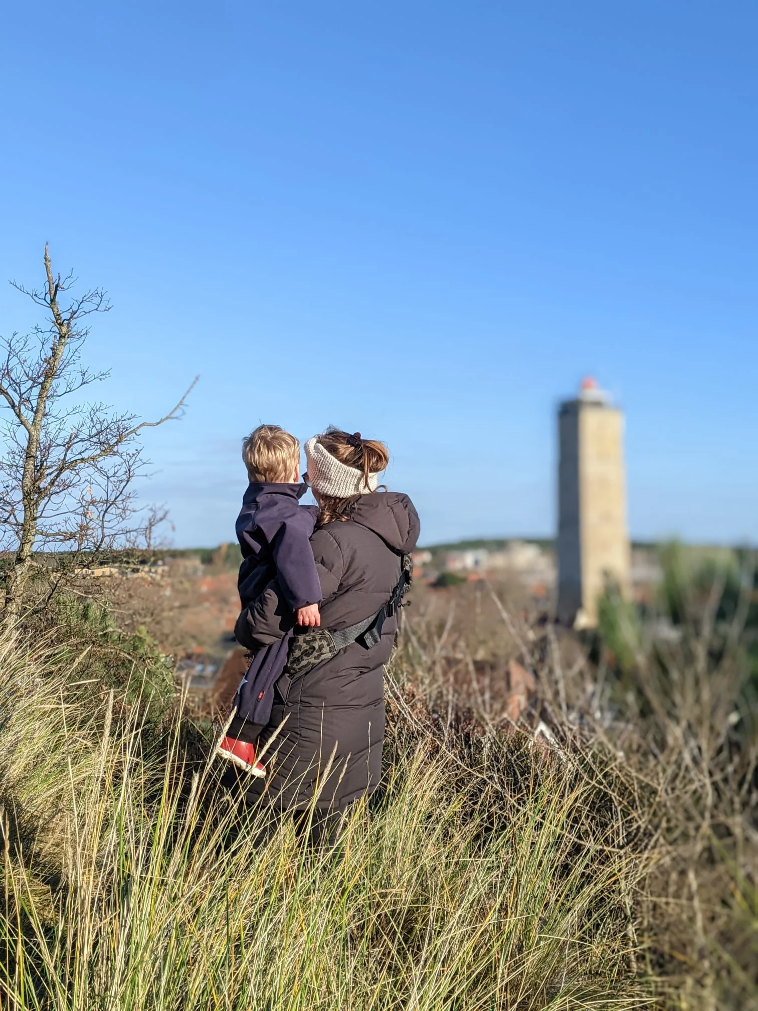 Moeder met kind op Terschelling met de Brandaris op de achtergrond