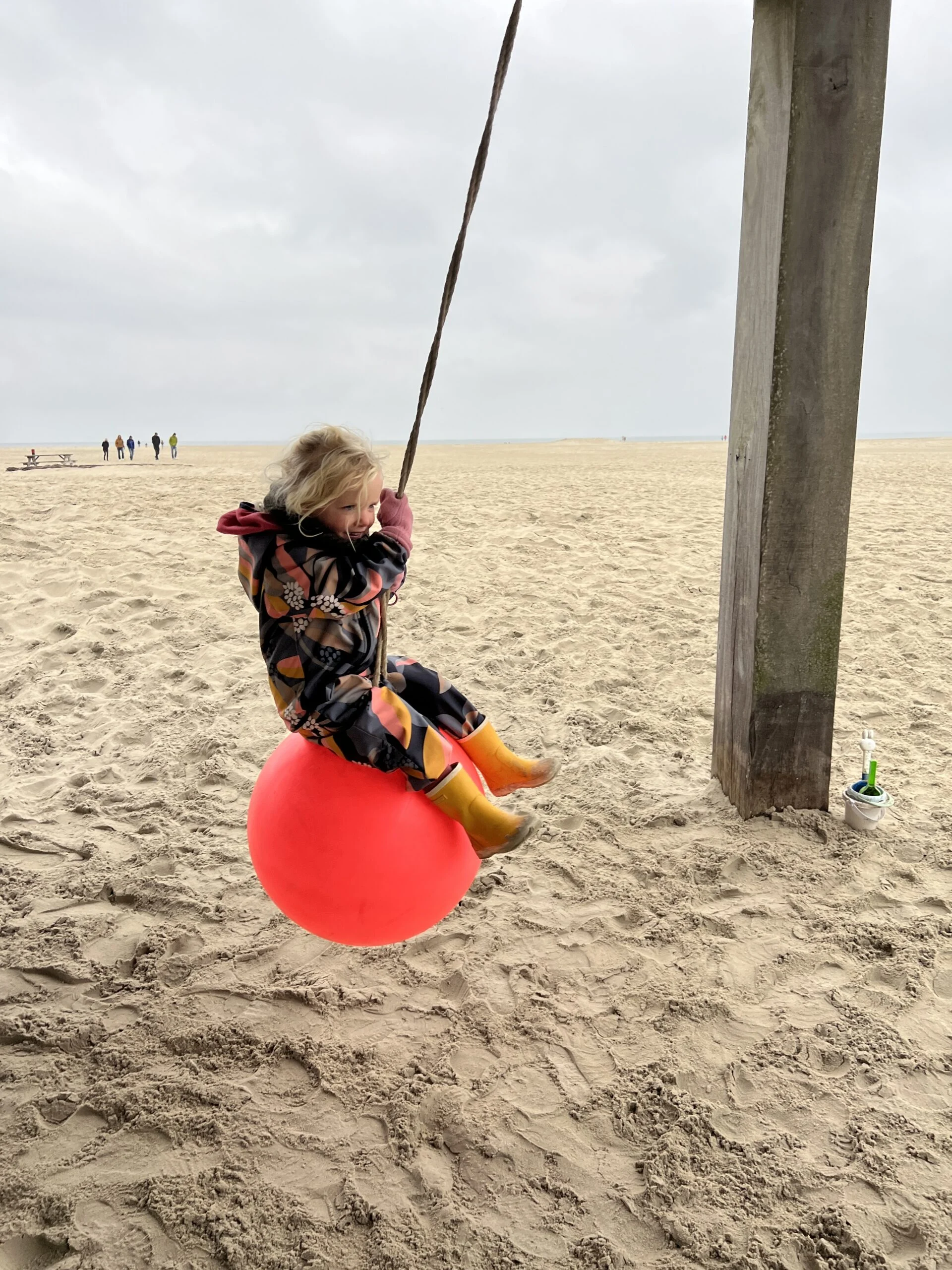 Kind draagt een buitenpak van Ielm op het strand van Terschelling