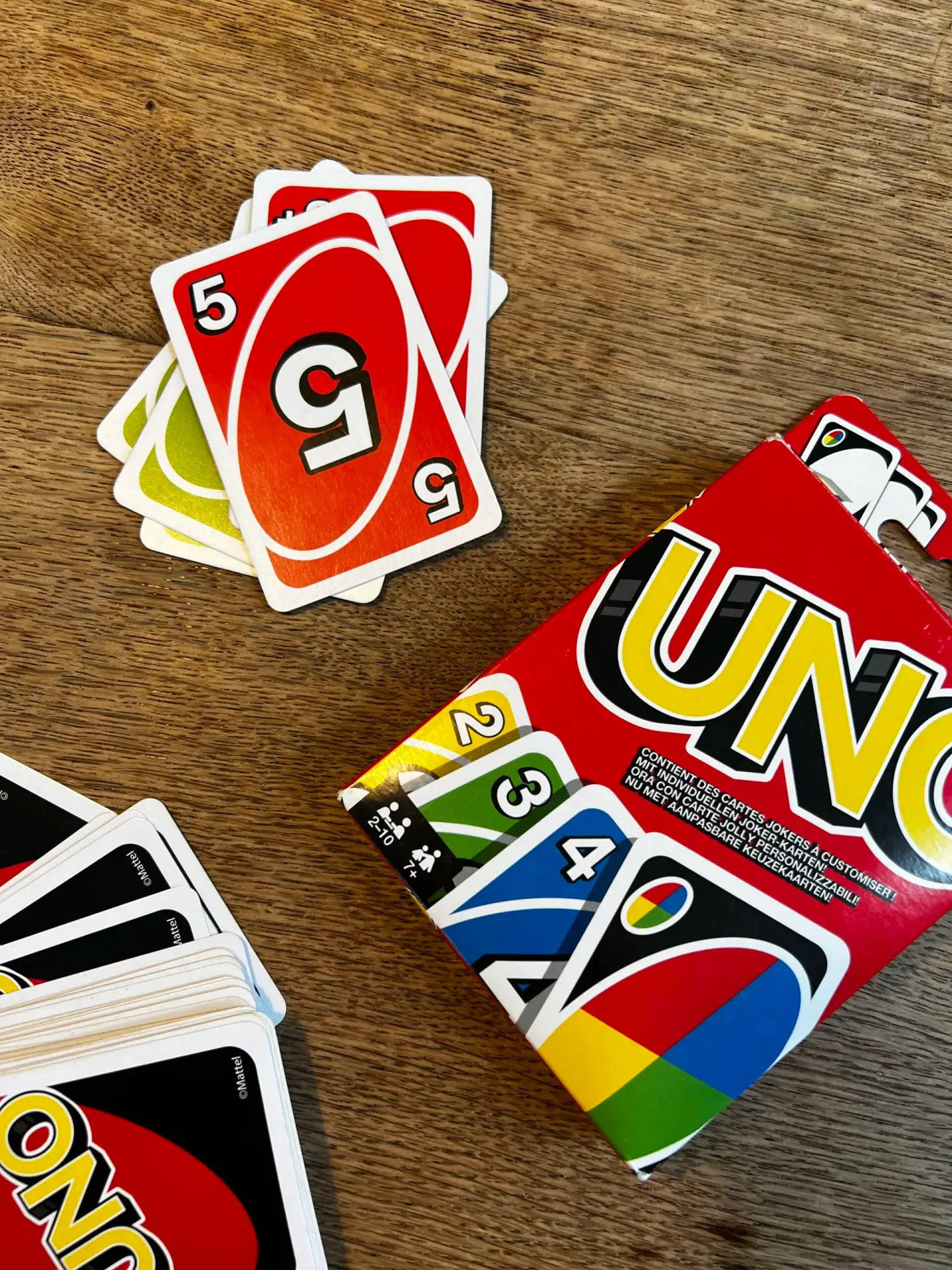 Kinderen spelen een potje Uno op de campingtafel tijdens een ontspannen middag buiten.