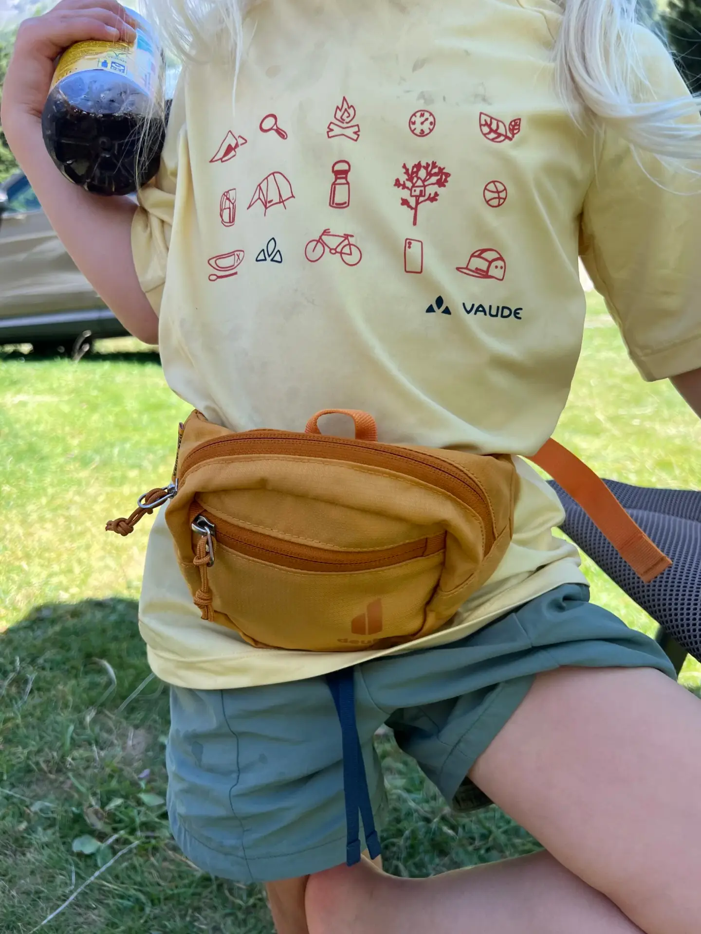 Een kind draagt de Deuter Junior Fanny Pack tijdens een wandeling in de natuur.