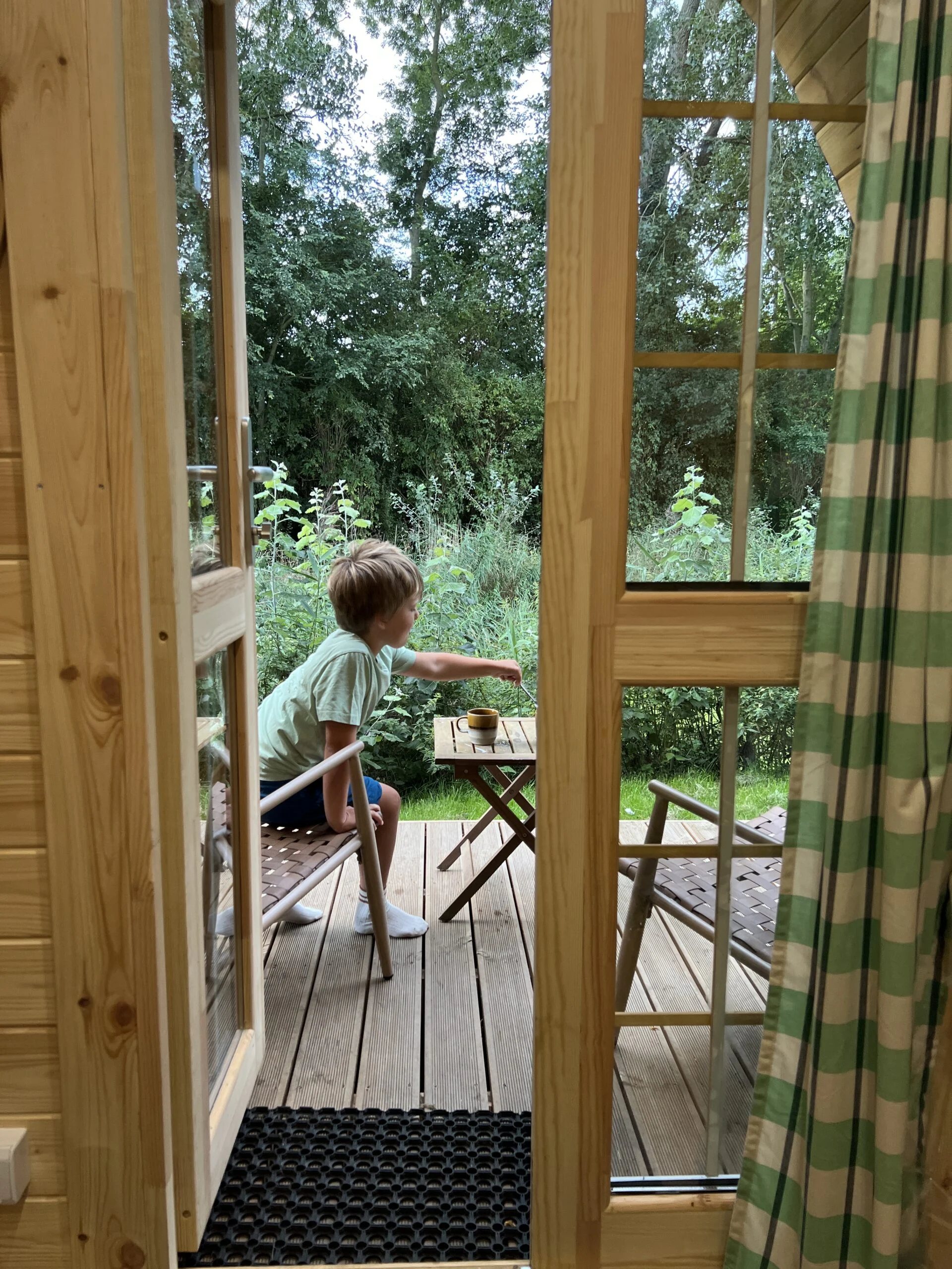 Kind aan het ontbijten aan een kampeertafeltje op de camping.