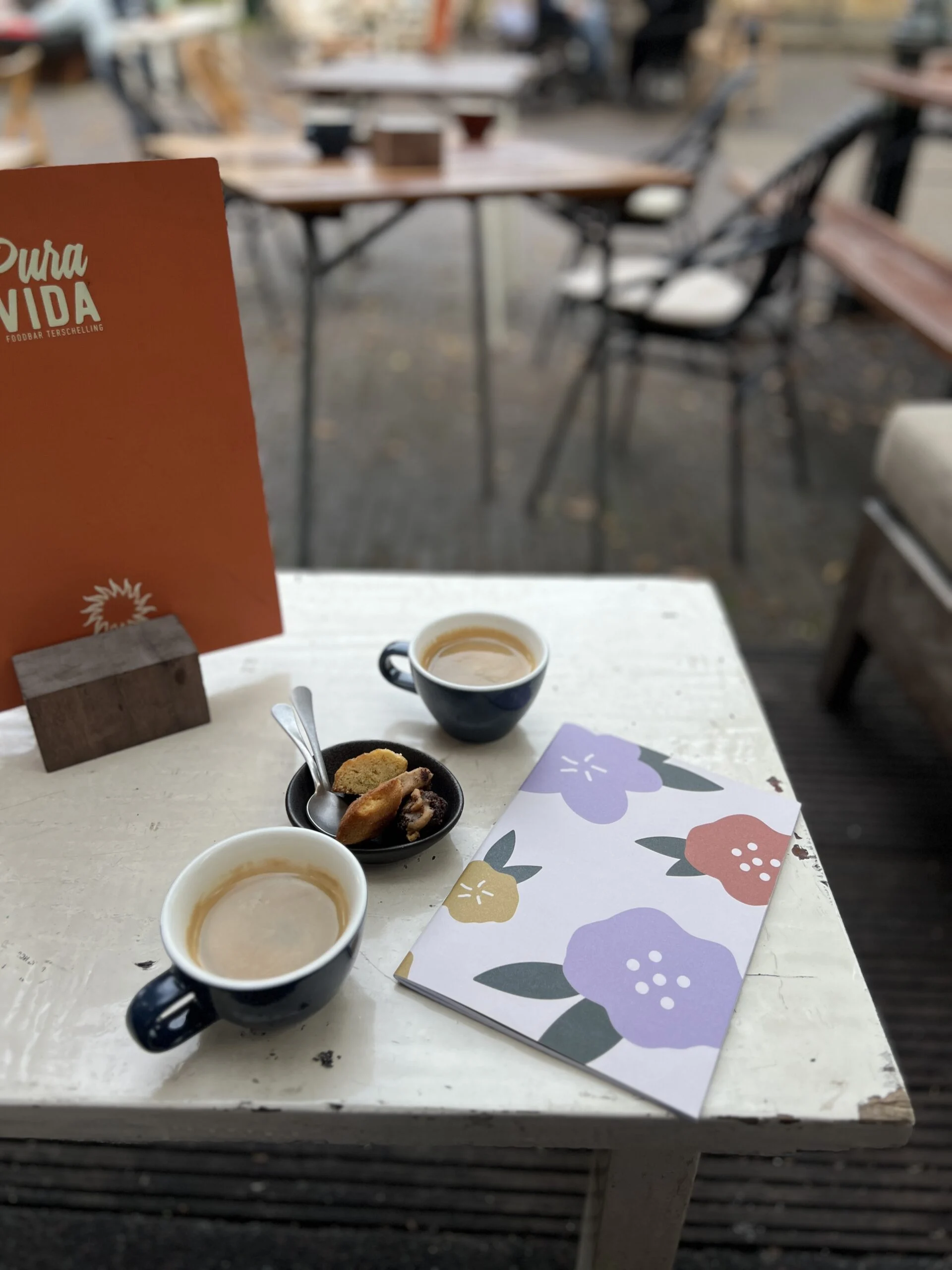 Kopjes koffie bij Pura Vida Foodbar op Terschelling met een notitieboekje van Schryft