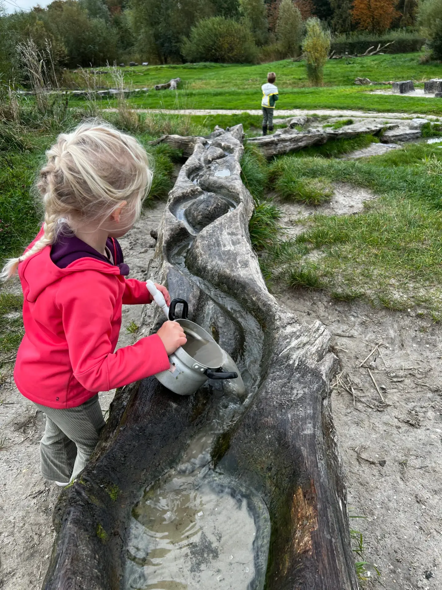Kind speelt met water in de natuurspeeltuin van OERRR Kardinge in Groningen