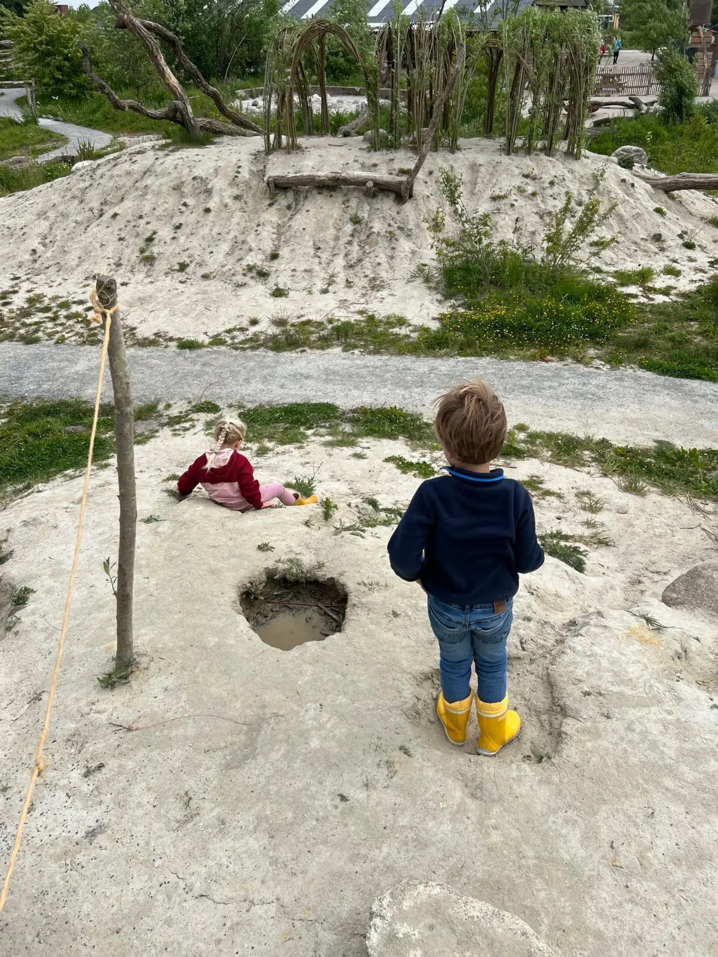 Twee kinderen spelen op heuveltjes in de natuurspeeltuin van OERRR De Onlanden bij Groningen een van de leukste natuurspeeltuinen in het Noorden van Nederland