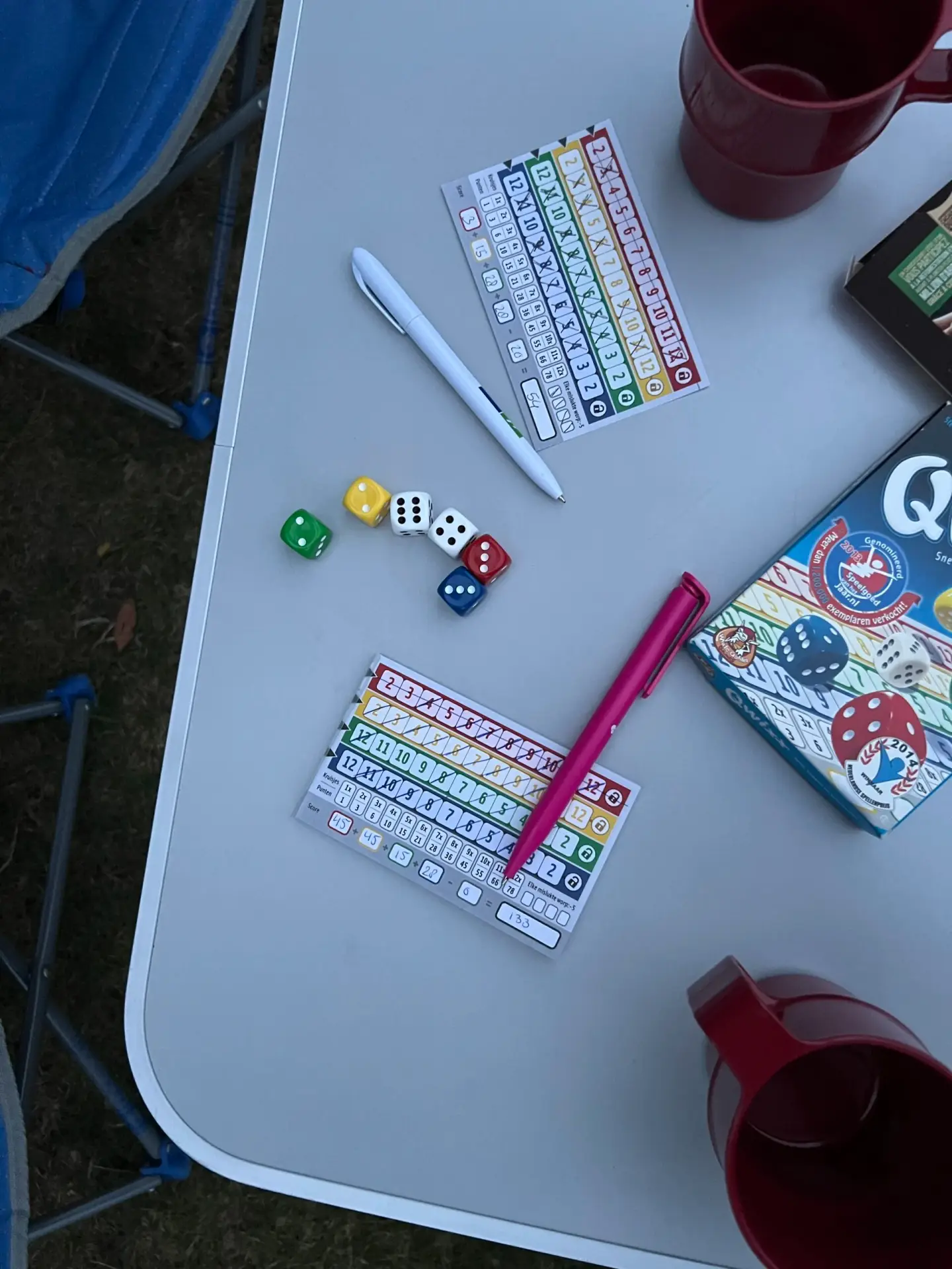 Gezinnen spelen het dobbelspel Qwixx op de camping