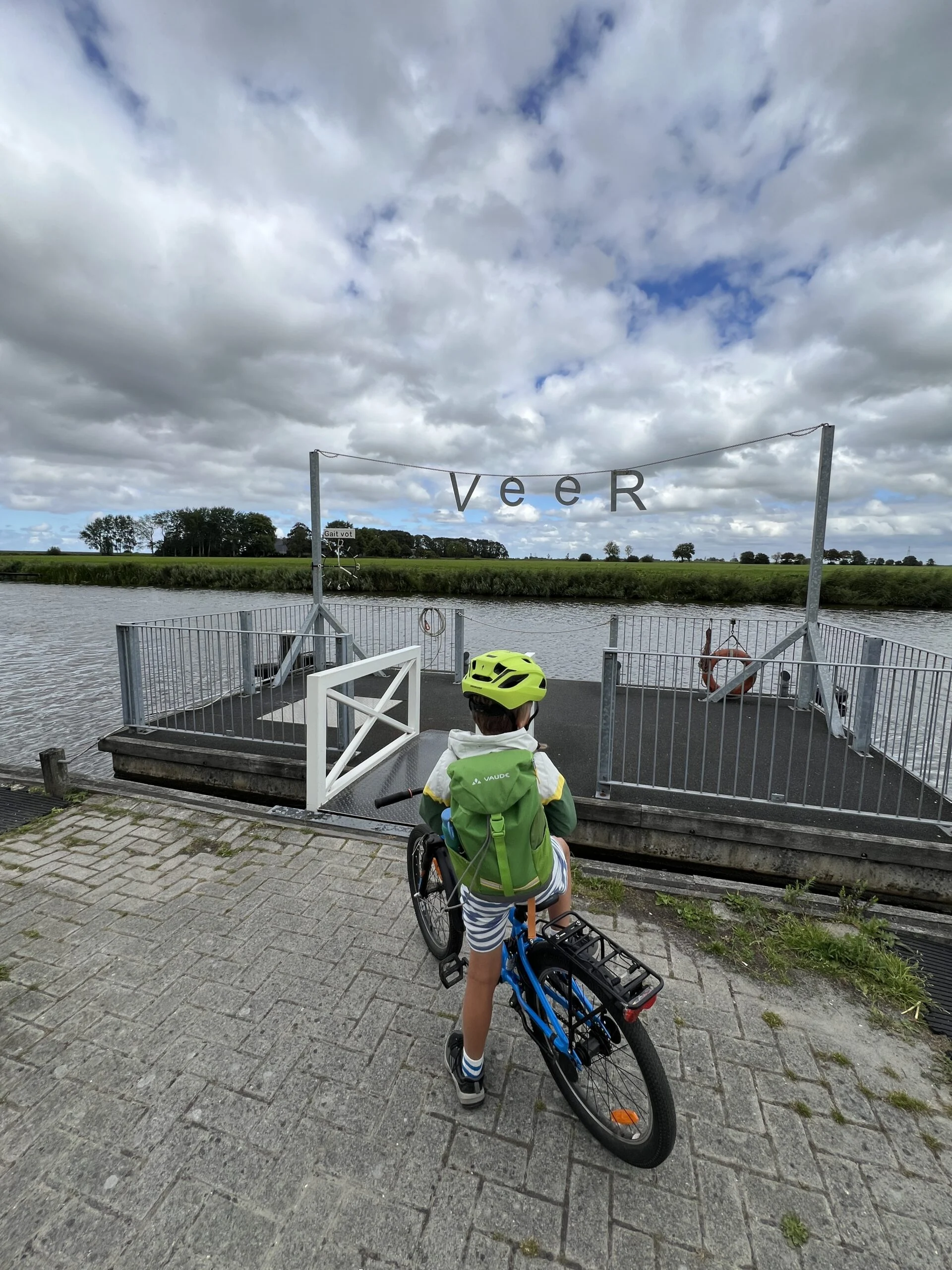 Kind op fietsvakantie wacht op fietspontje de Reitdiepveer in Aduarderzijl, Groningen
