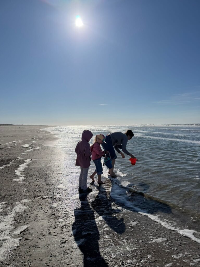Kinderen spelen in het water aan de rand van de zee op het strand van Terschelling