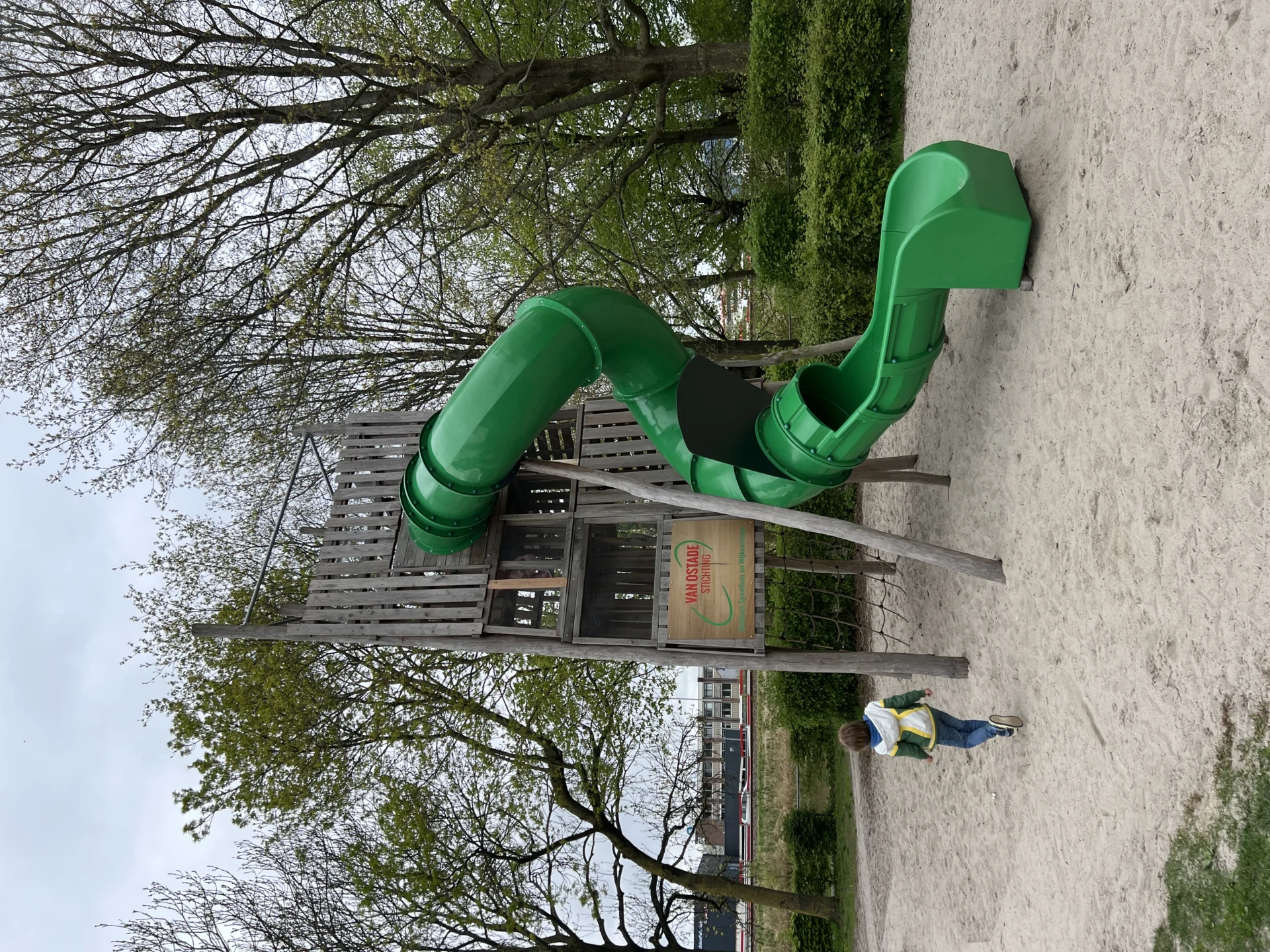 Grote groene glijbaan in een speeltuin in de Schildersbuurt in Groningen