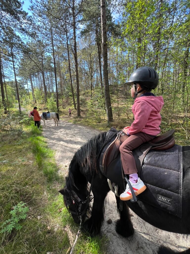 Kind rijdt op een pony door het bos op Terschelling