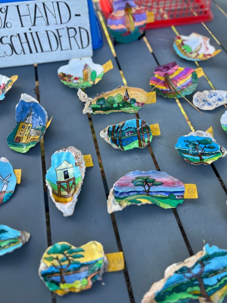 Schelpen beschilderd met kenmerkende beelden van Terschelling als souvenir van het Waddeneiland