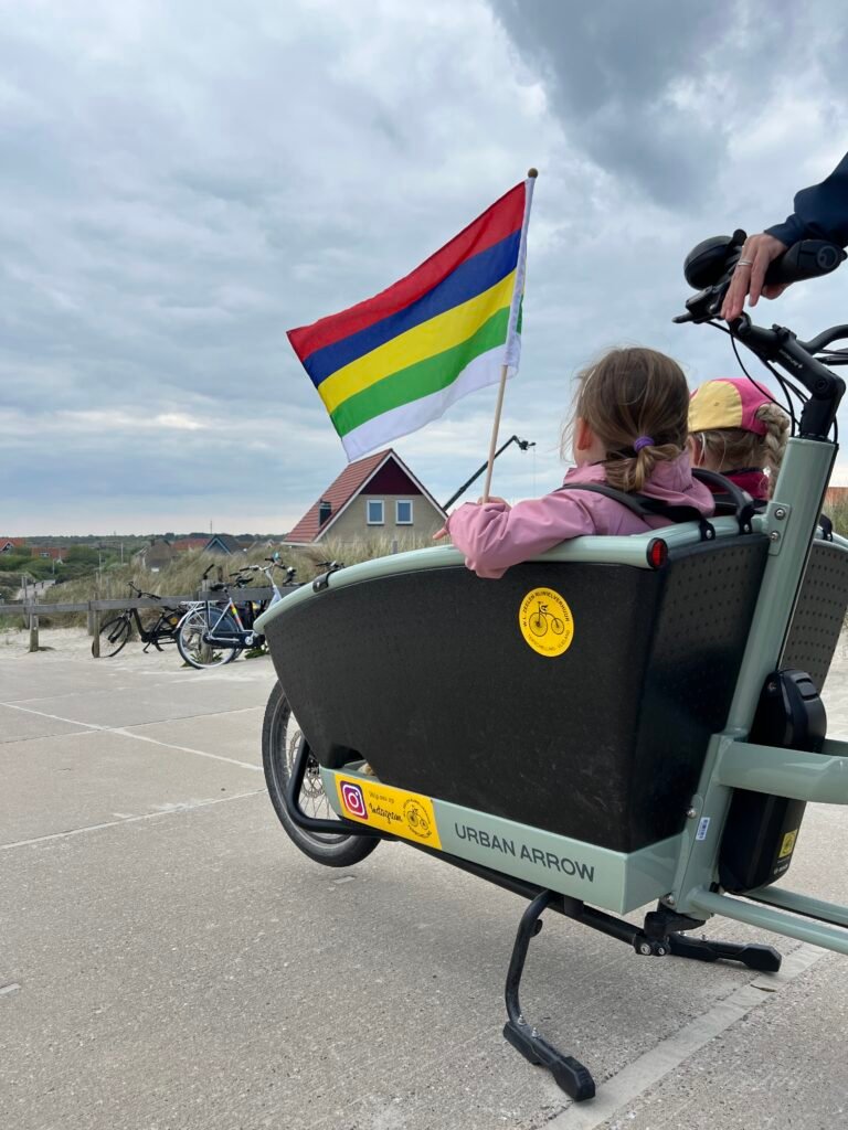Kinderen zitten in een gehuurde bakfiets van fietsverhuur Zeelen op Terschelling