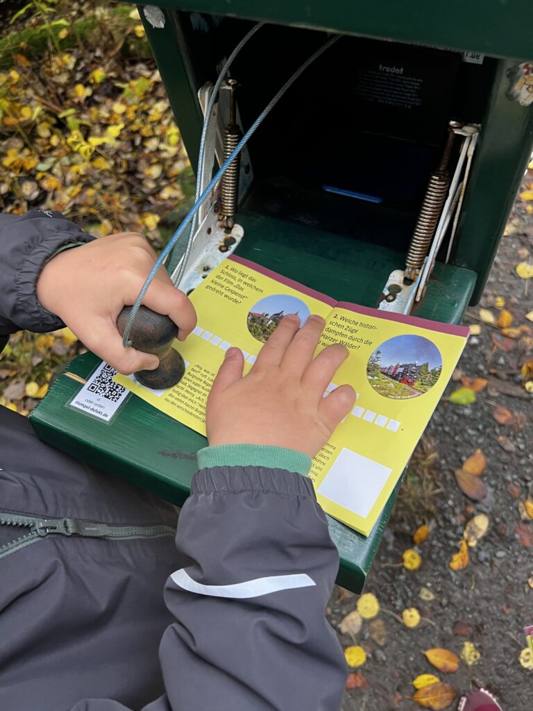 Kind zet stempel van de Harzer Wandernadel in boekje van de Brocken Bende