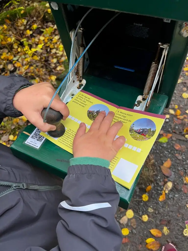 Kind zet stempel van de Harzer Wandernadel in boekje van de Brocken Bende