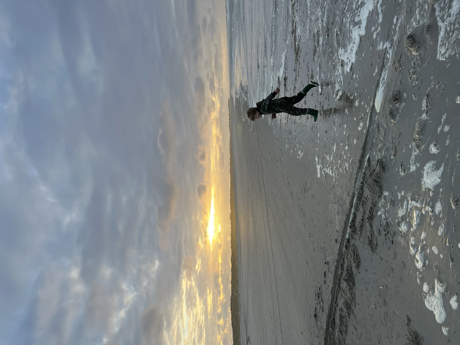Kind dat rent op het strand op een Waddeneiland