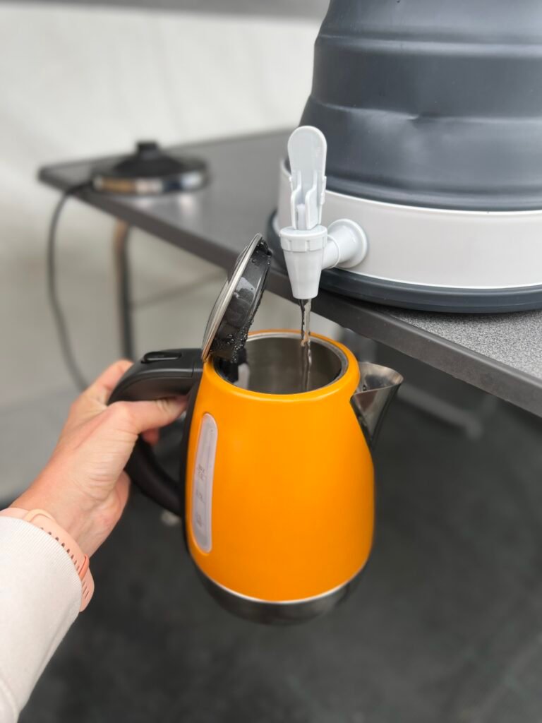 Opvouwbare jerrycan met kraantje vult waterkoker op de camping, handige kampeerspullen