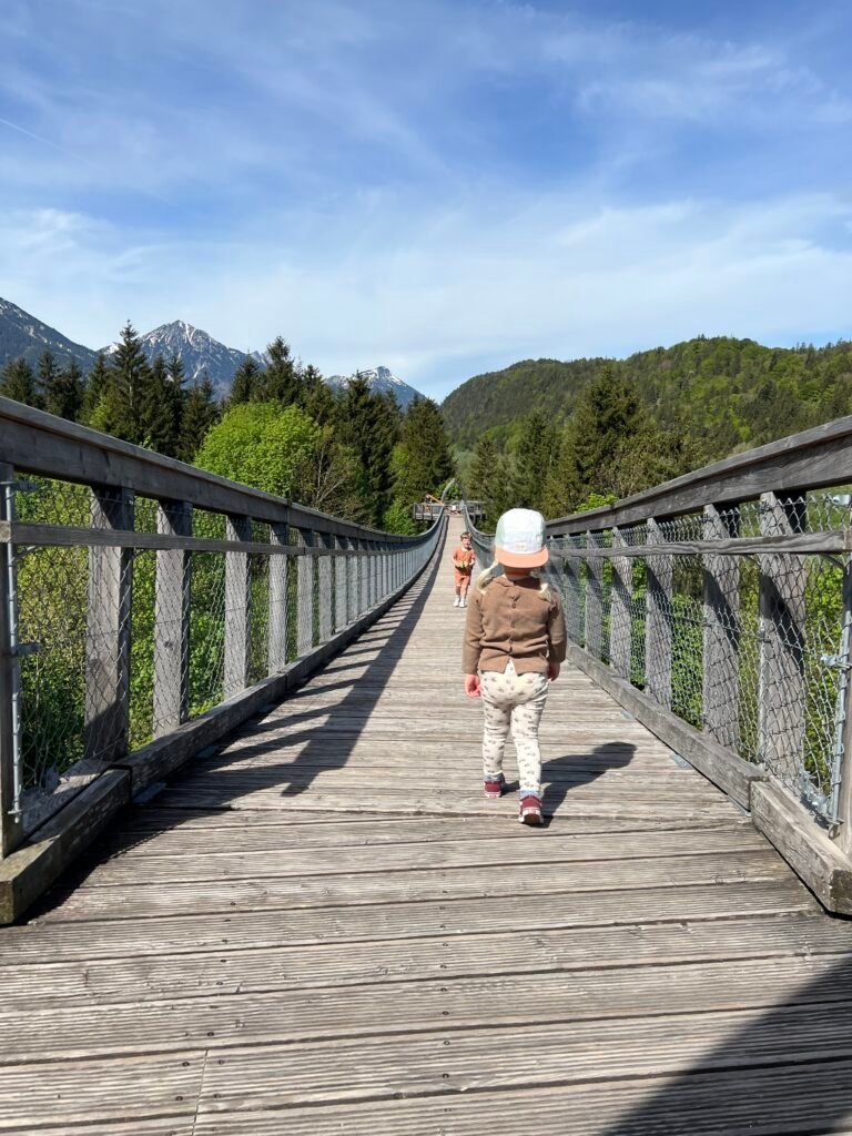 Kind loopt over het boomkroonpad van Walderlebniszentrum Füssen in Allgäu, een kindvriendelijk uitje in Beieren