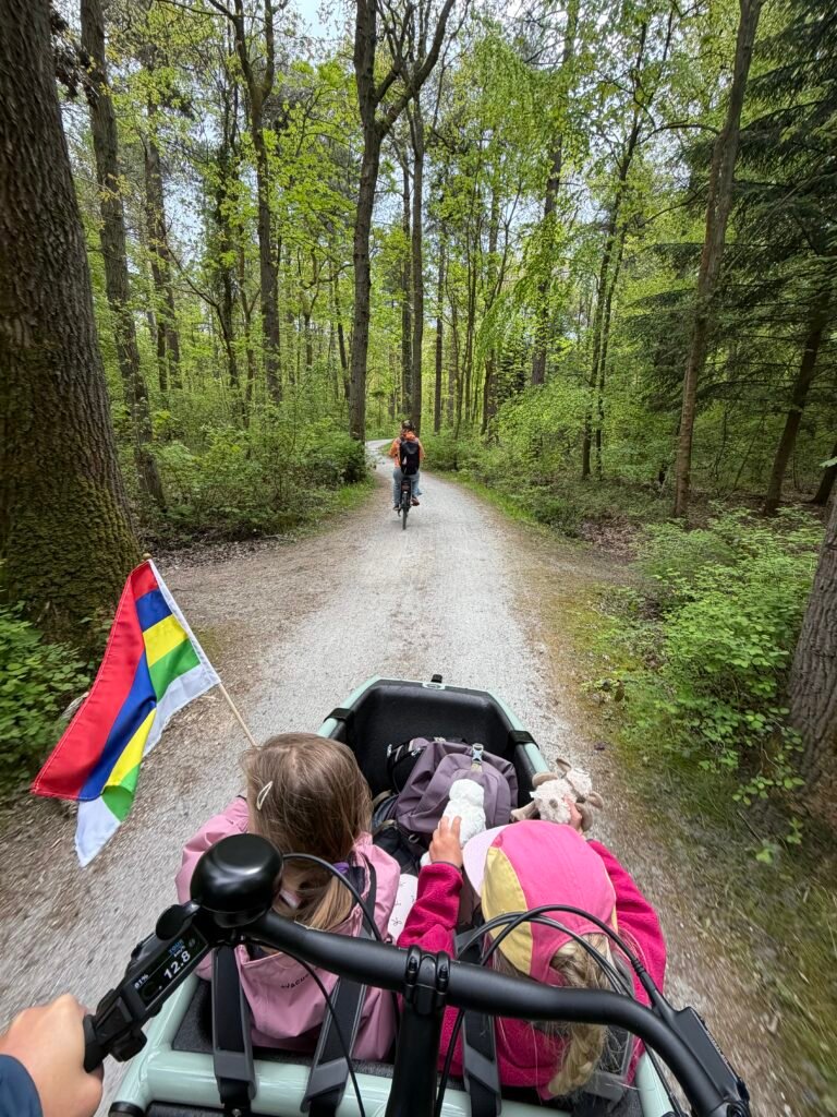 Kinderen rijden in een gehuurde bakfiets van Zeelen door het bos van Terschelling