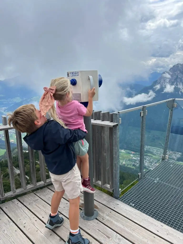 Kinderen kijken door verrekijker bij uitzichtpunt in Stubai