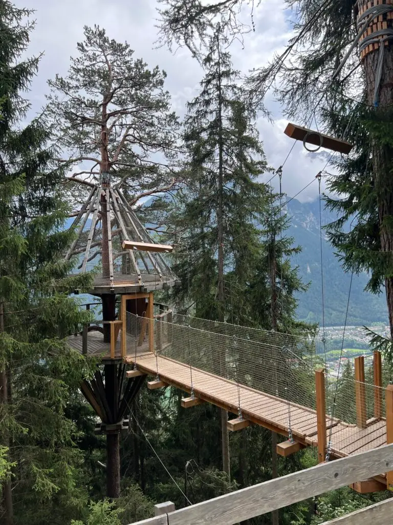 Boomhut met loopbrug tussen de bomen op de Baumhausweg Stubai