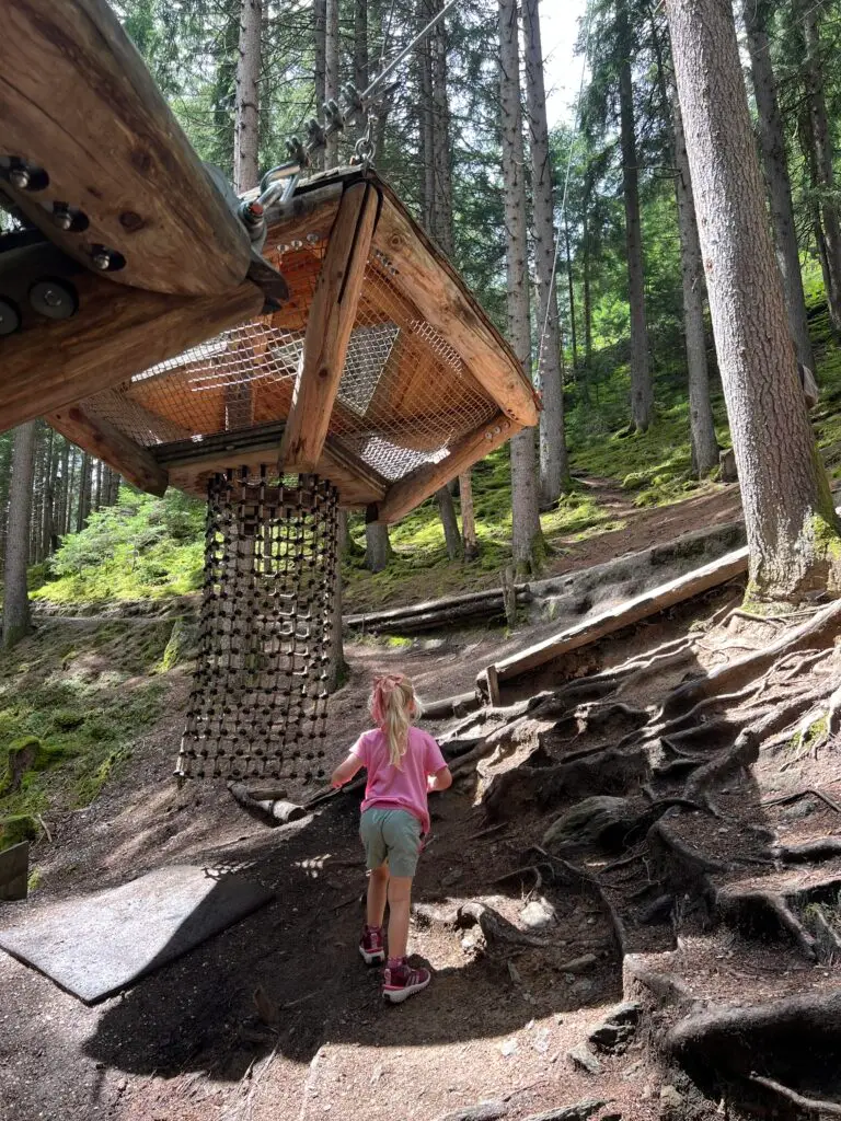 Kind klimt van onderaf de slaap-boomhut in op de Baumhausweg Stubai