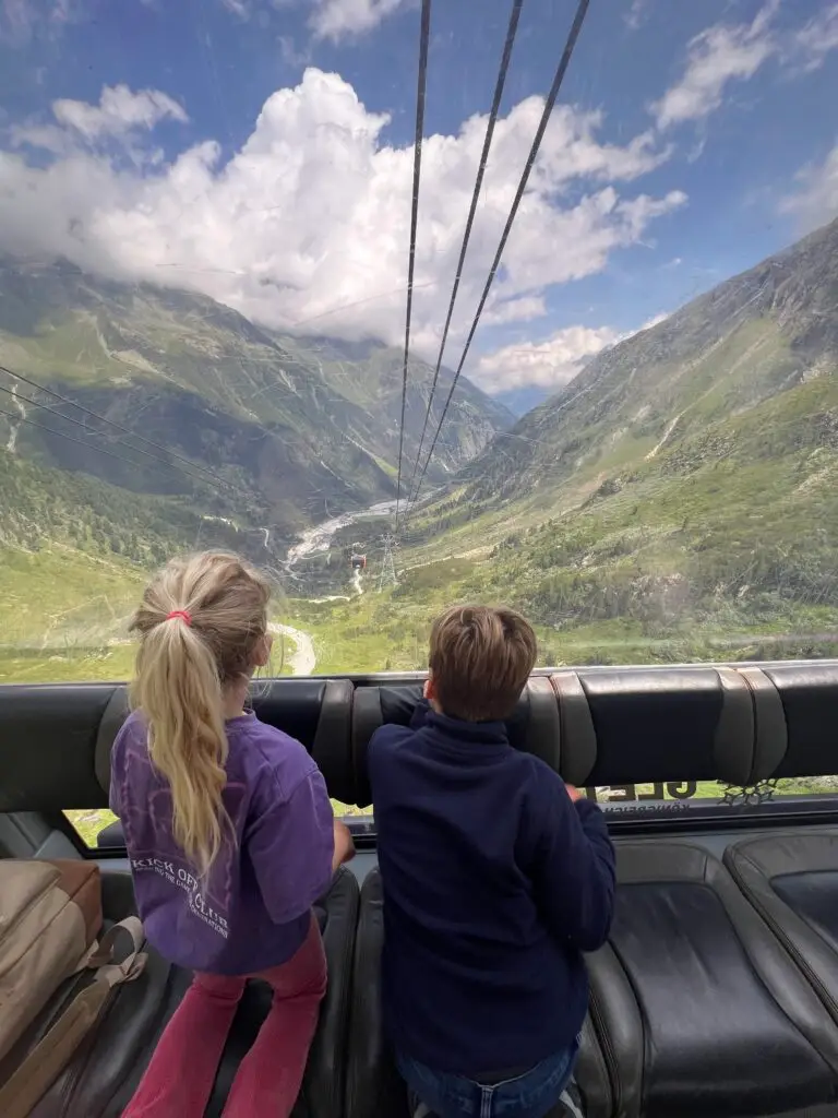 Twee kinderen kijken naar beneden vanuit gondel Stubaier Gletscher
