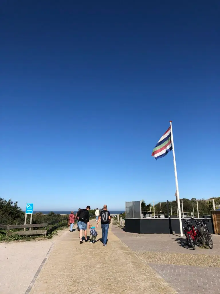 Strandopgang Schiermonnikoog met vlag tegen blauwe lucht