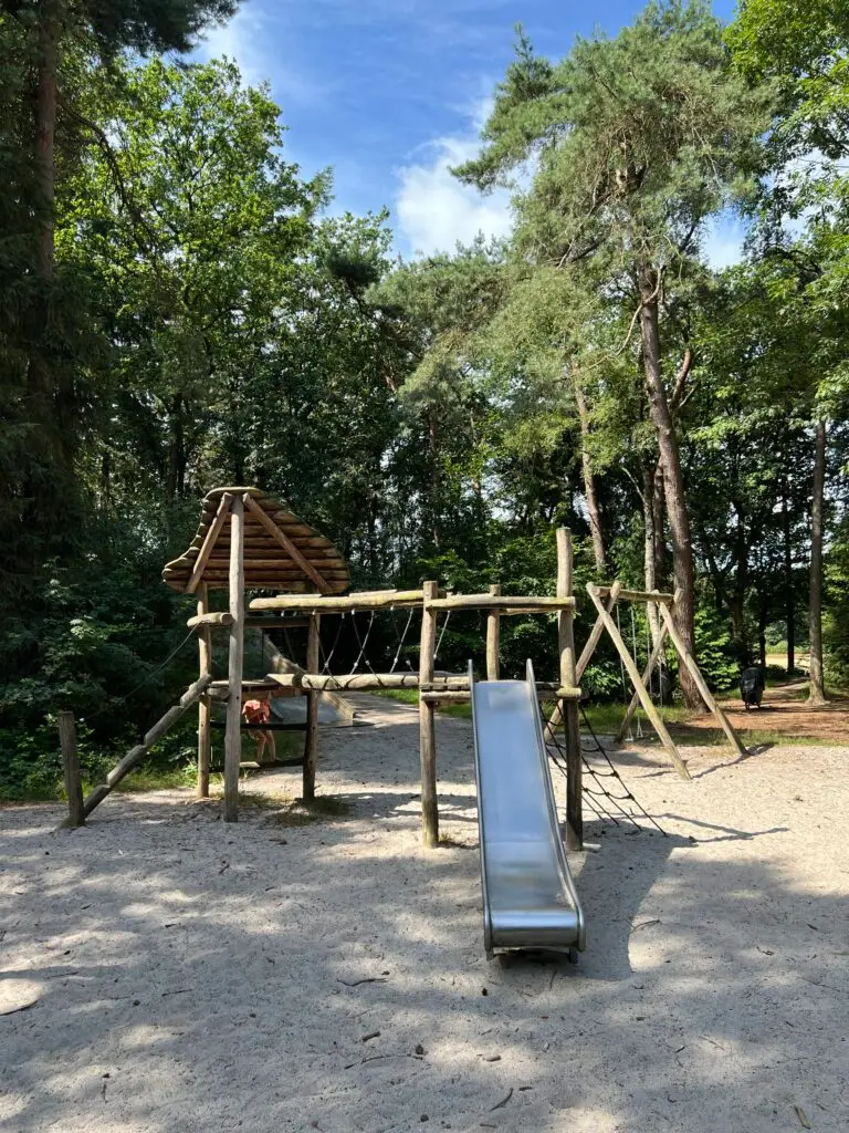 Houten speeltoestel met glijbaan in het speelbos in Friesland