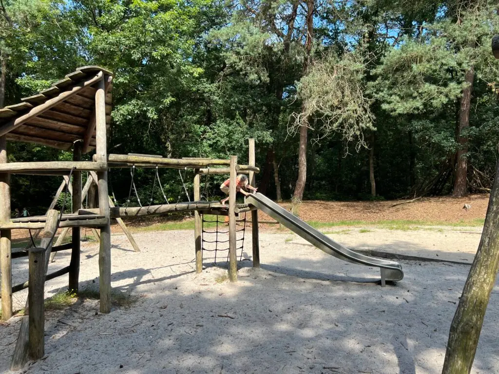 Groot houten speeltoestel met glijbaan bij de speeltuin in het Blauwe Bos Friesland