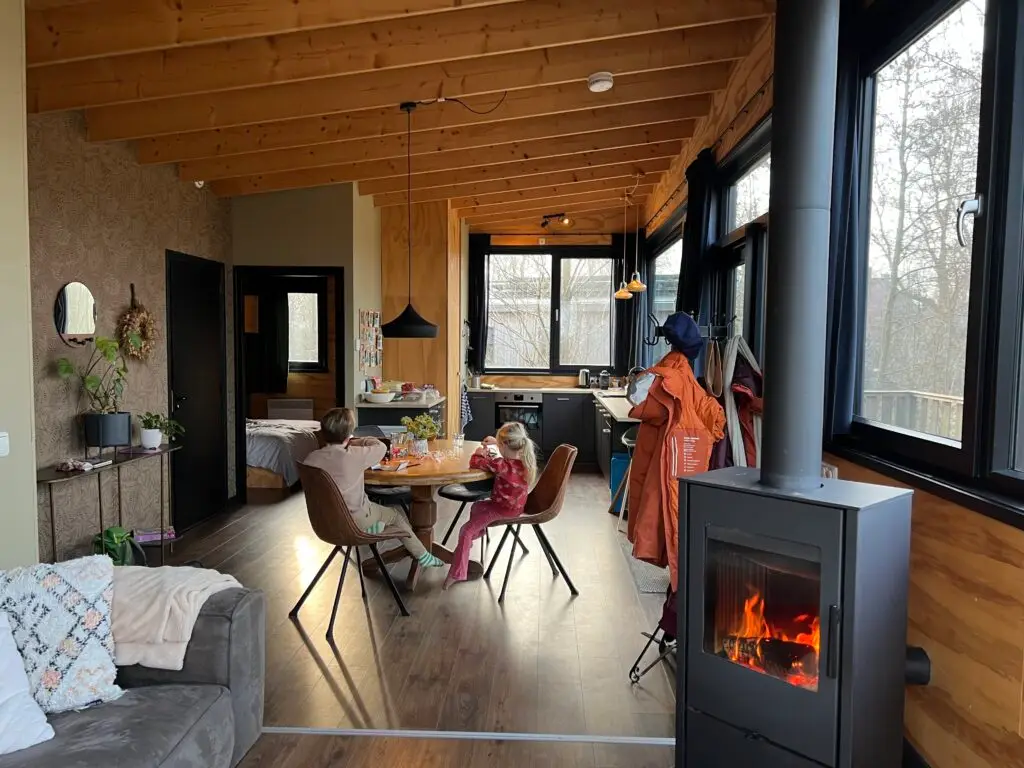 Eettafel en keuken van waterlodge Pean Buiten met brandende houtkachel