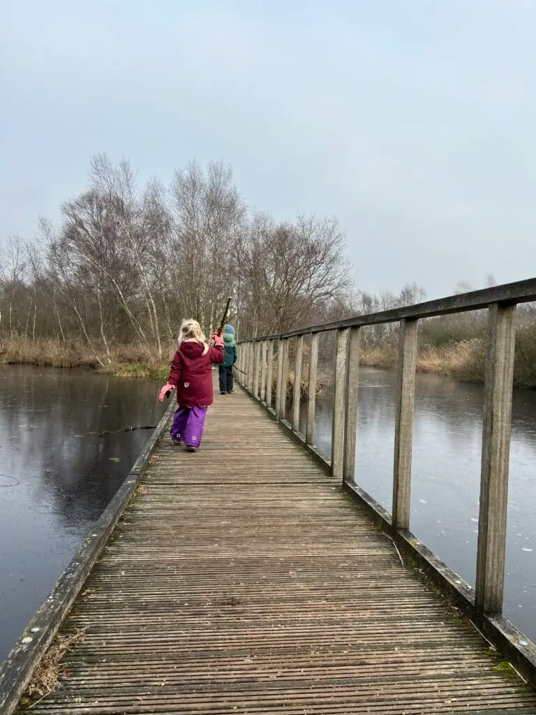 Kind loopt op vlonderpad bij De Deelen in Friesland op een winterse dag