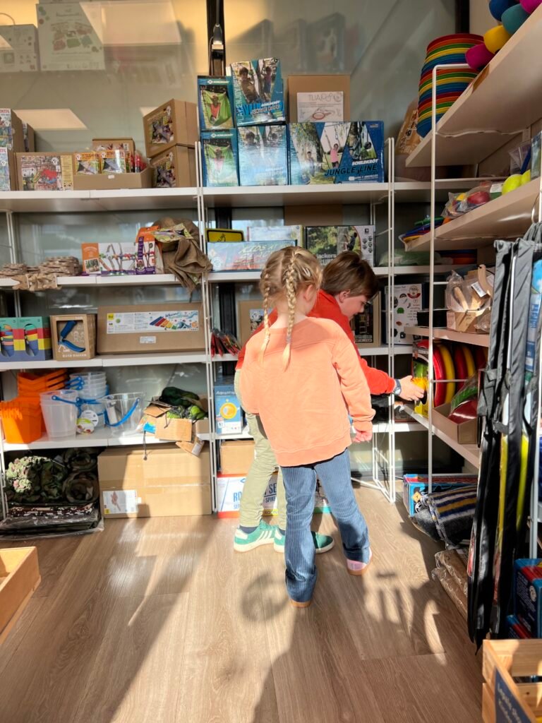 Twee kinderen bekijken buitenspeelgoed in speelgoedwinkel OpZijnPlek in Noordwolde