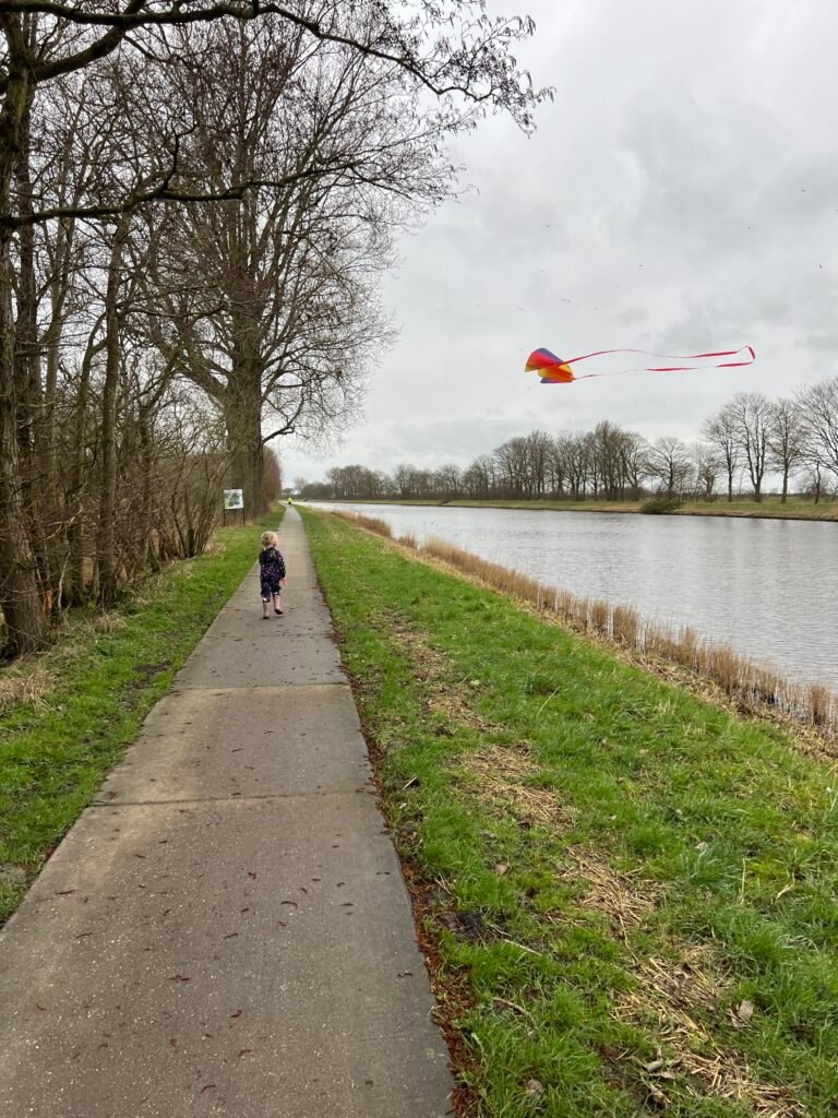 Kind rent met een vlieger die opstijgt tijdens het buiten spelen