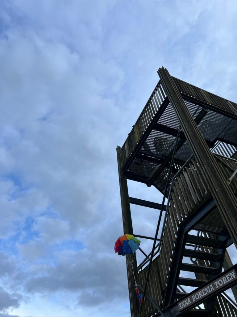 Kinderen gooien een parachute met een pop eraan van een uitkijktoren
