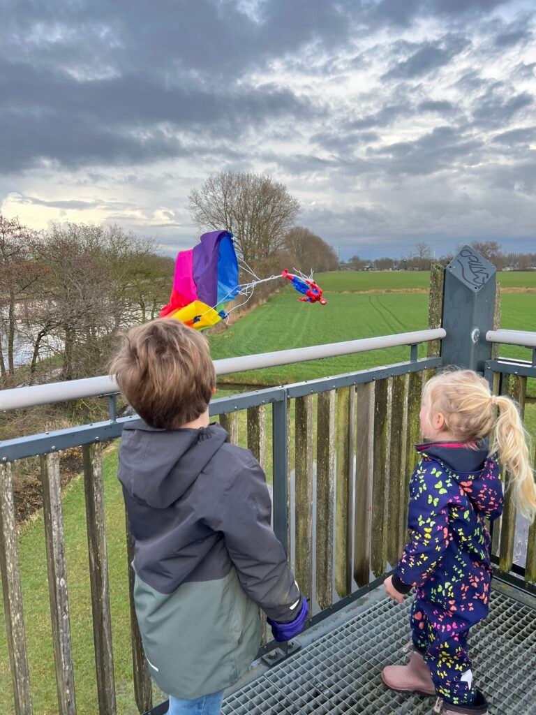 Parachute met een pop eraan valt naar beneden, gezien vanaf de uitkijktoren