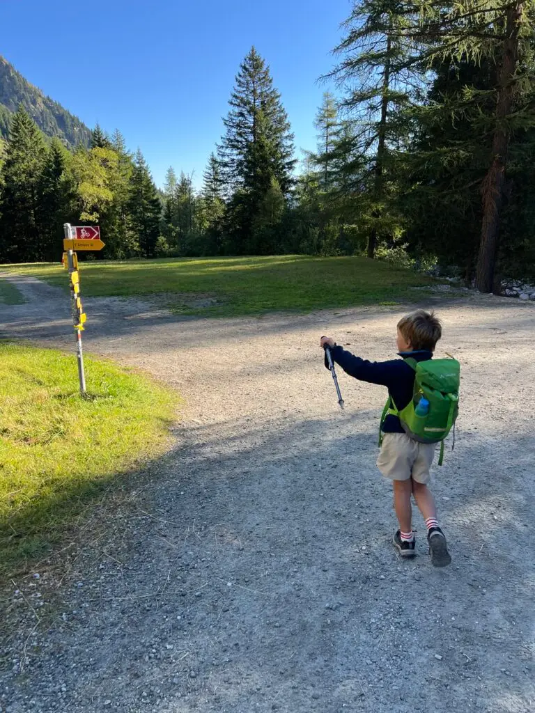 Kind start wandeling Tour du Mont Blanc bij La Fouly, Zwitserland tijdens een vakantie in de bergen met kinderen