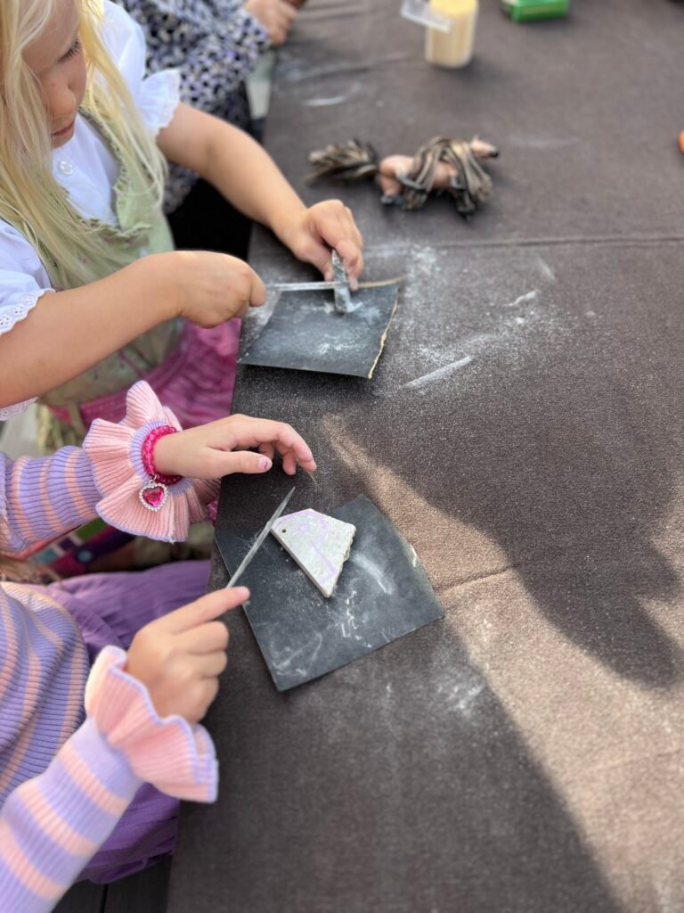 Kinderen maken amuletten van speksteen tijdens een creatief kinderfeestje thuis