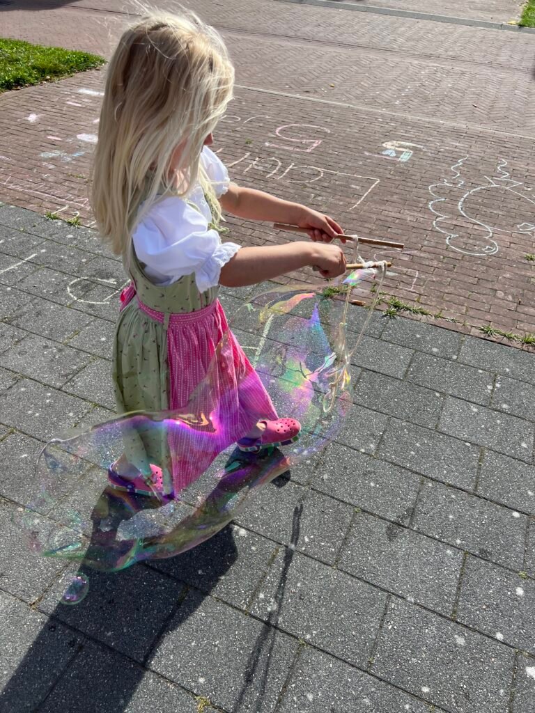 De jarige, een meisje, maakt zelf megabubbels op een kinderfeestje thuis