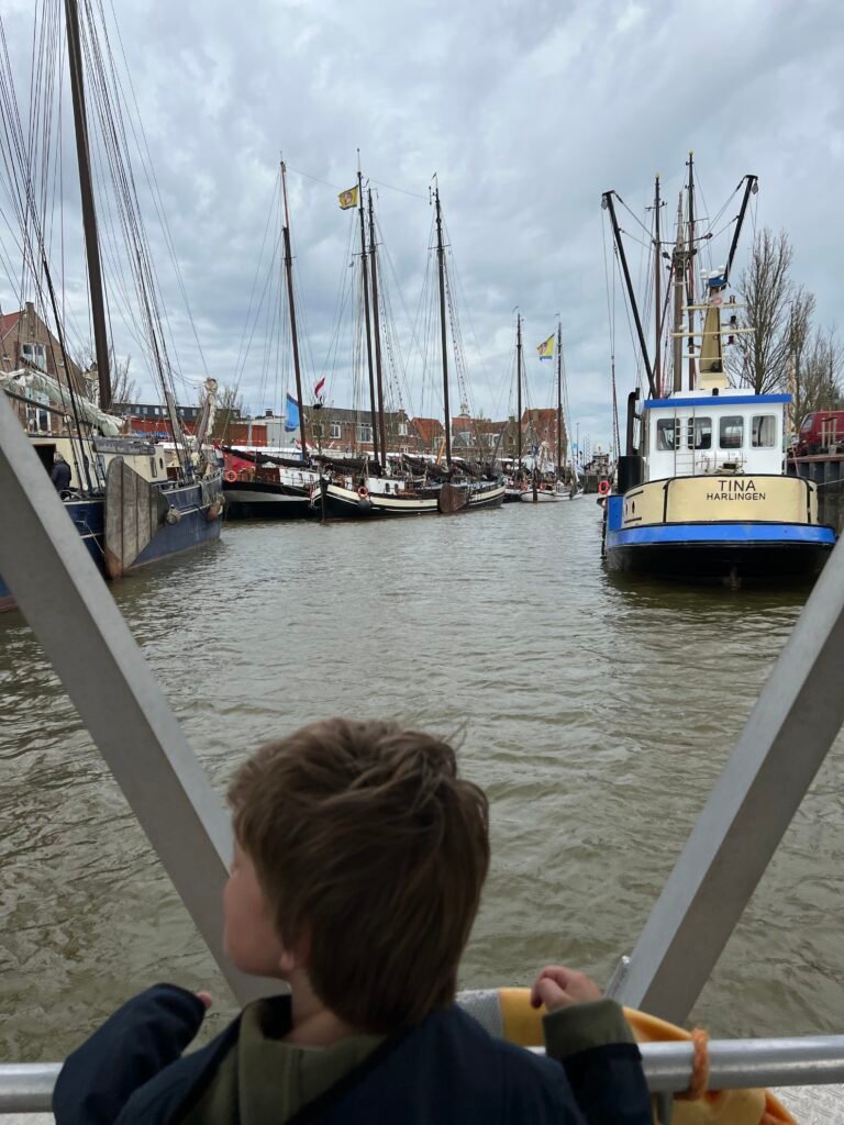 Kind vaart met pontje door haven van Harlingen tijdens Open Watersport Weken Friesland