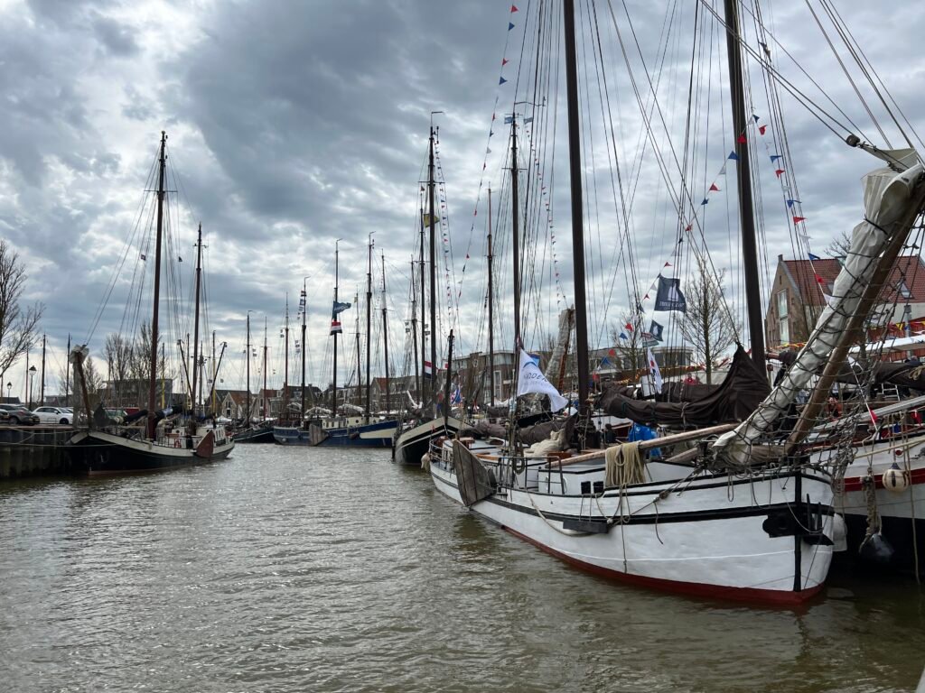 Boten in de haven van Harlingen gezien vanaf het water tijdens Open Watersport Weken Friesland