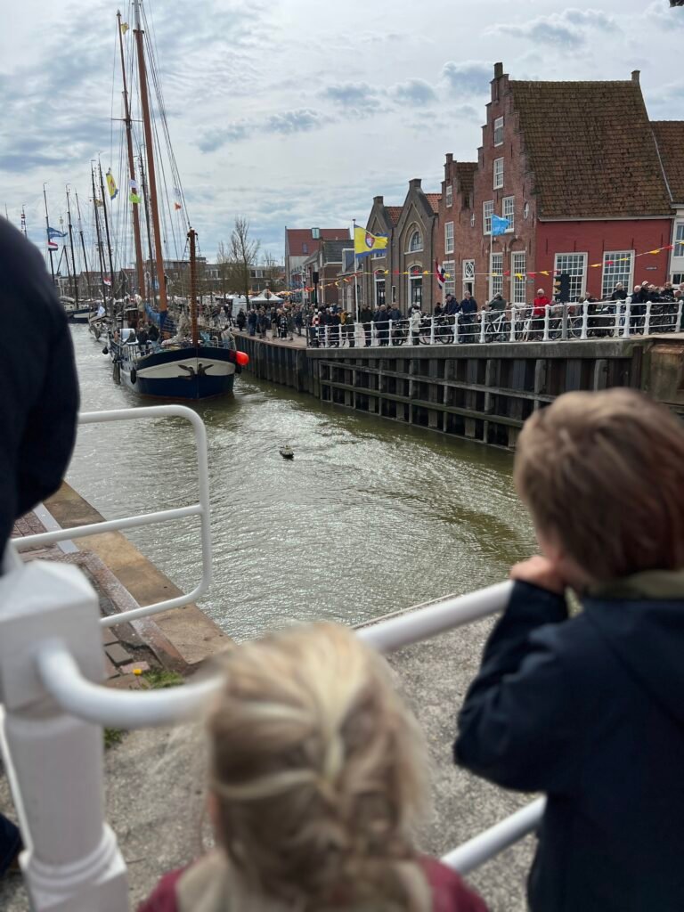 Kinderen kijken naar boot die de haven van Harlingen binnenvaart tijdens Open Watersport Weken Friesland