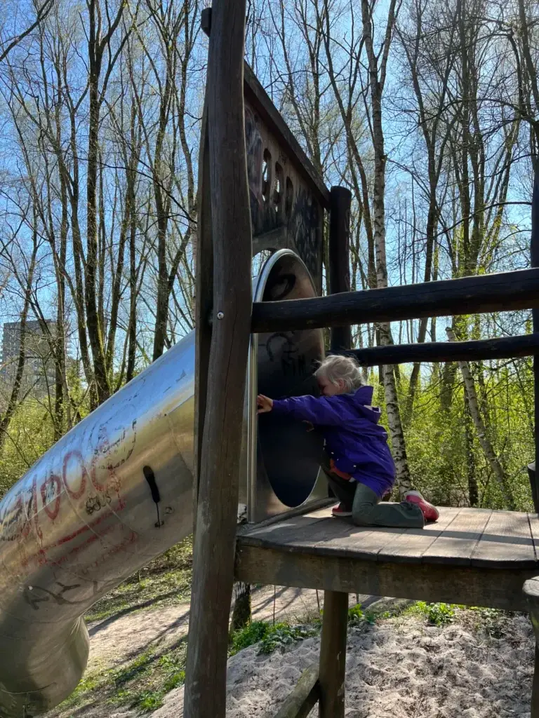 Kind dat van de glijbaan afgaat in ’t Roege Bos in Groningen