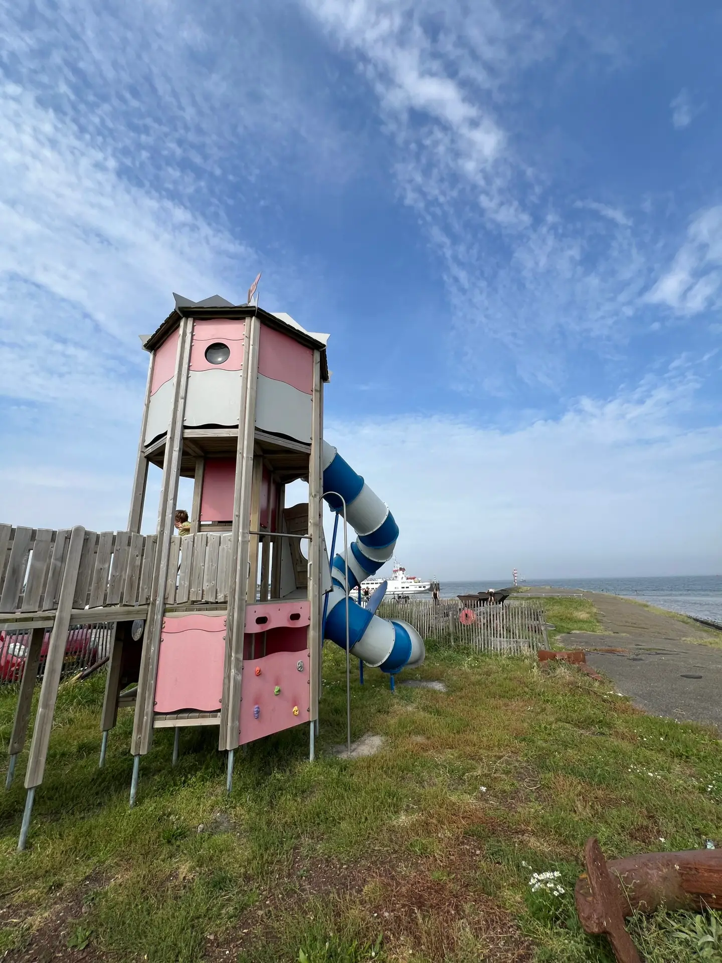 Speeltoestel met glijbaan en uitzicht op de Waddenzee in de haven van Lauwersoog